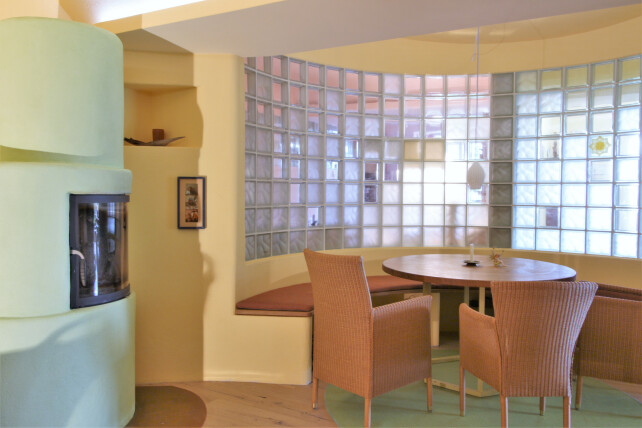 Innenraumansicht auf Ofen und Sitzbereich vor Glasbausteinwand
